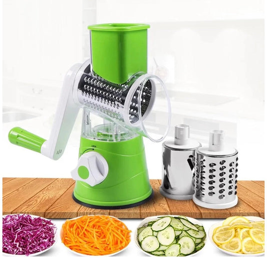 Green manual vegetable spiralizer with attached blades on a wooden surface, surrounded by sliced vegetables.